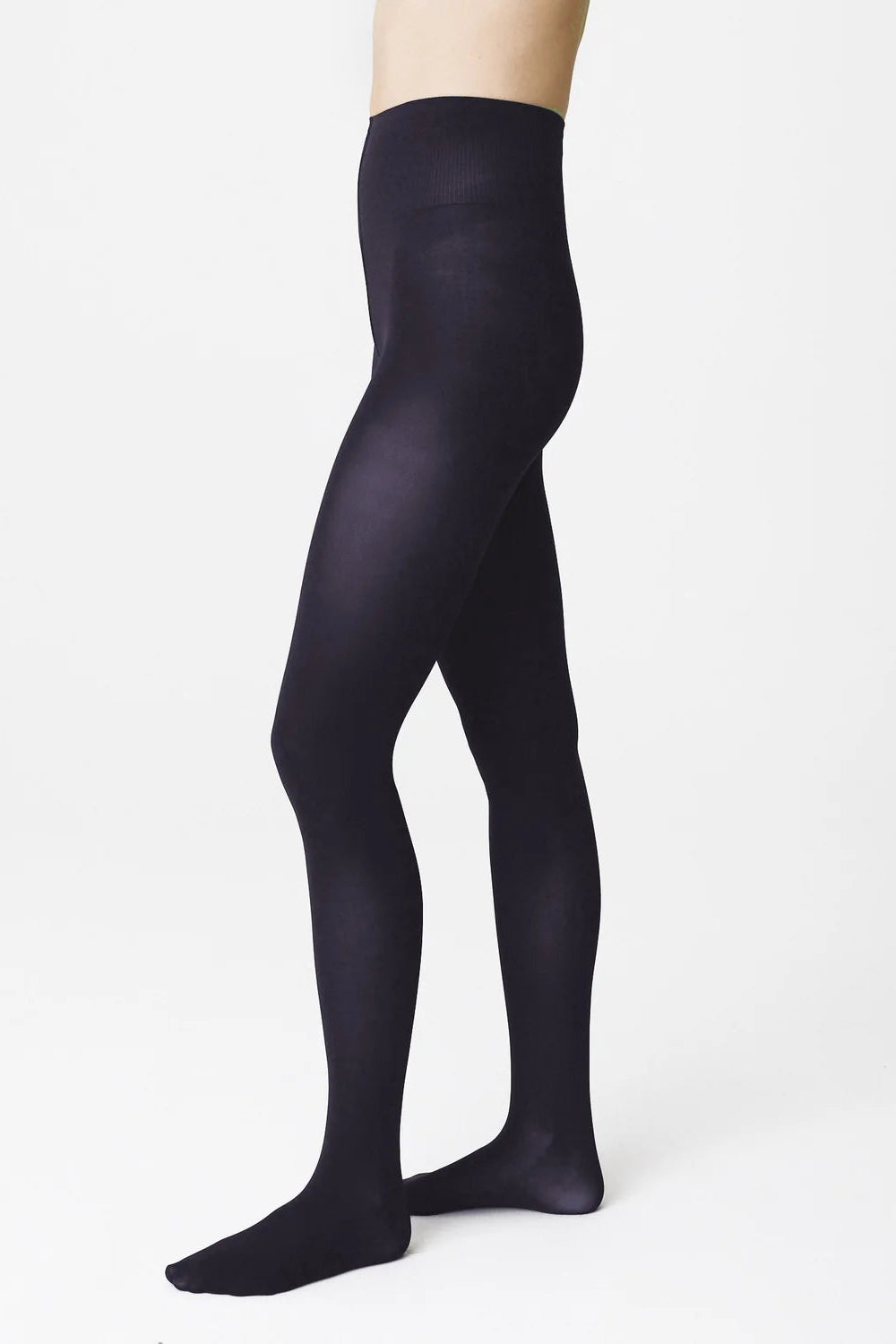 A model's legs wearing black tights, shown from the waist down in a side profile against a clean white studio background. - 3
