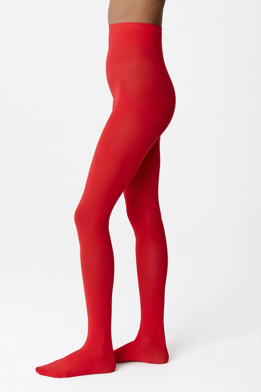 Red opaque tights worn on a model's legs, shown from the waist down in a side profile against a clean white studio background.