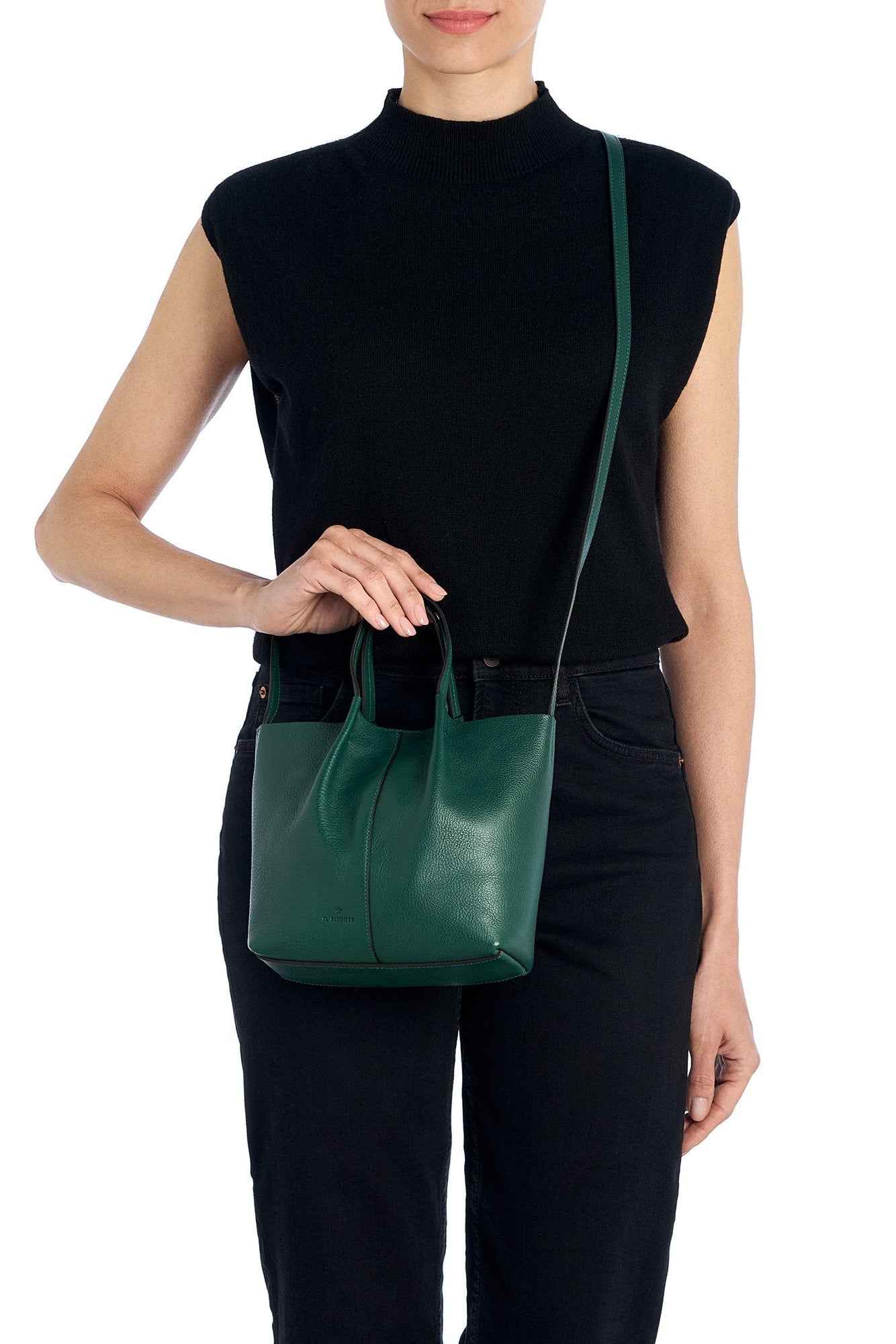 Person holding a green handbag against a white background