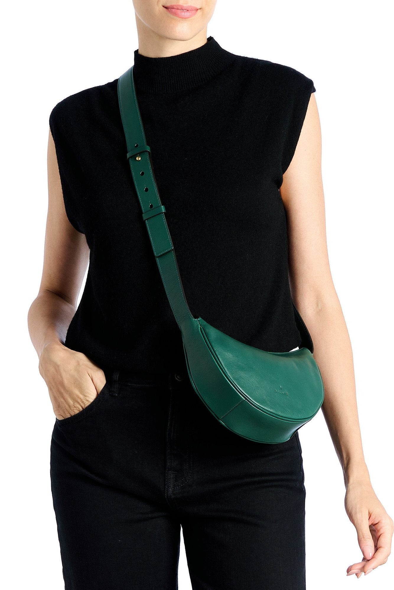 Person wearing a green crossbody bag on a white background