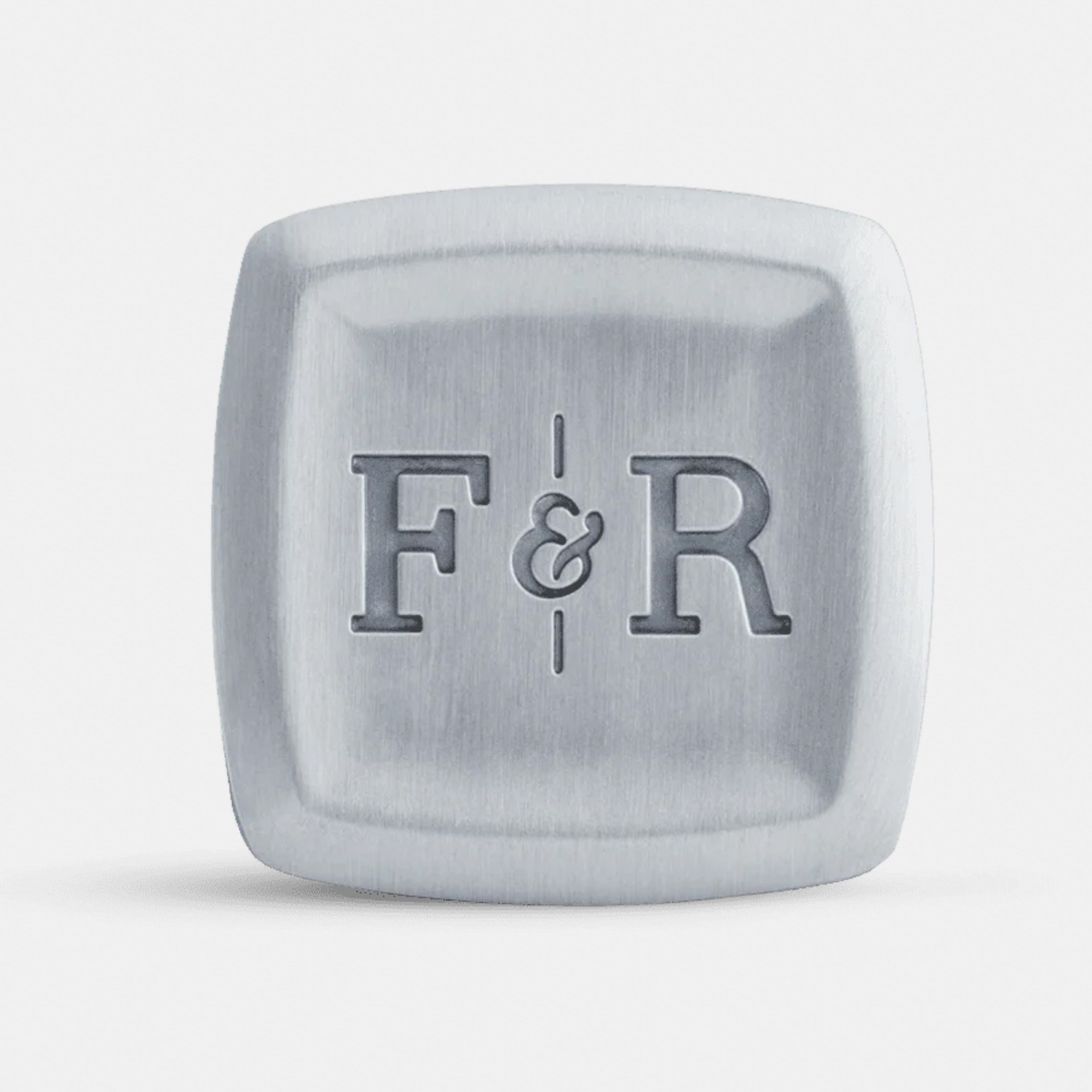 A square metallic accessory with rounded corners, featuring the engraved initials 'F&R' in the center, shown on a clean light gray background.