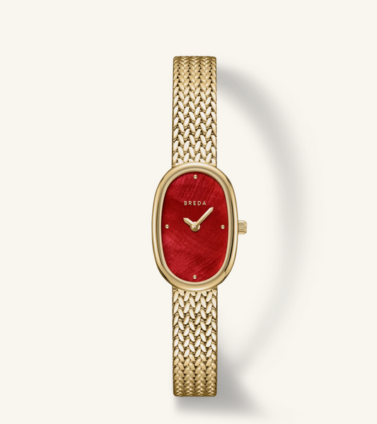 A Breda women's watch featuring an oval gold-tone case, a textured red dial, and a matching gold-tone mesh bracelet, presented on a clean off-white background.
